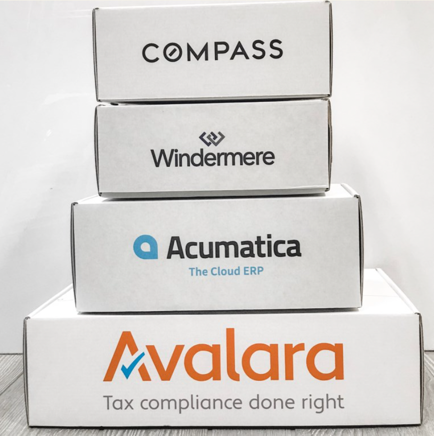 four custom gift boxes with corporate logos, Avalara, Acumatica, Windermere, Compass