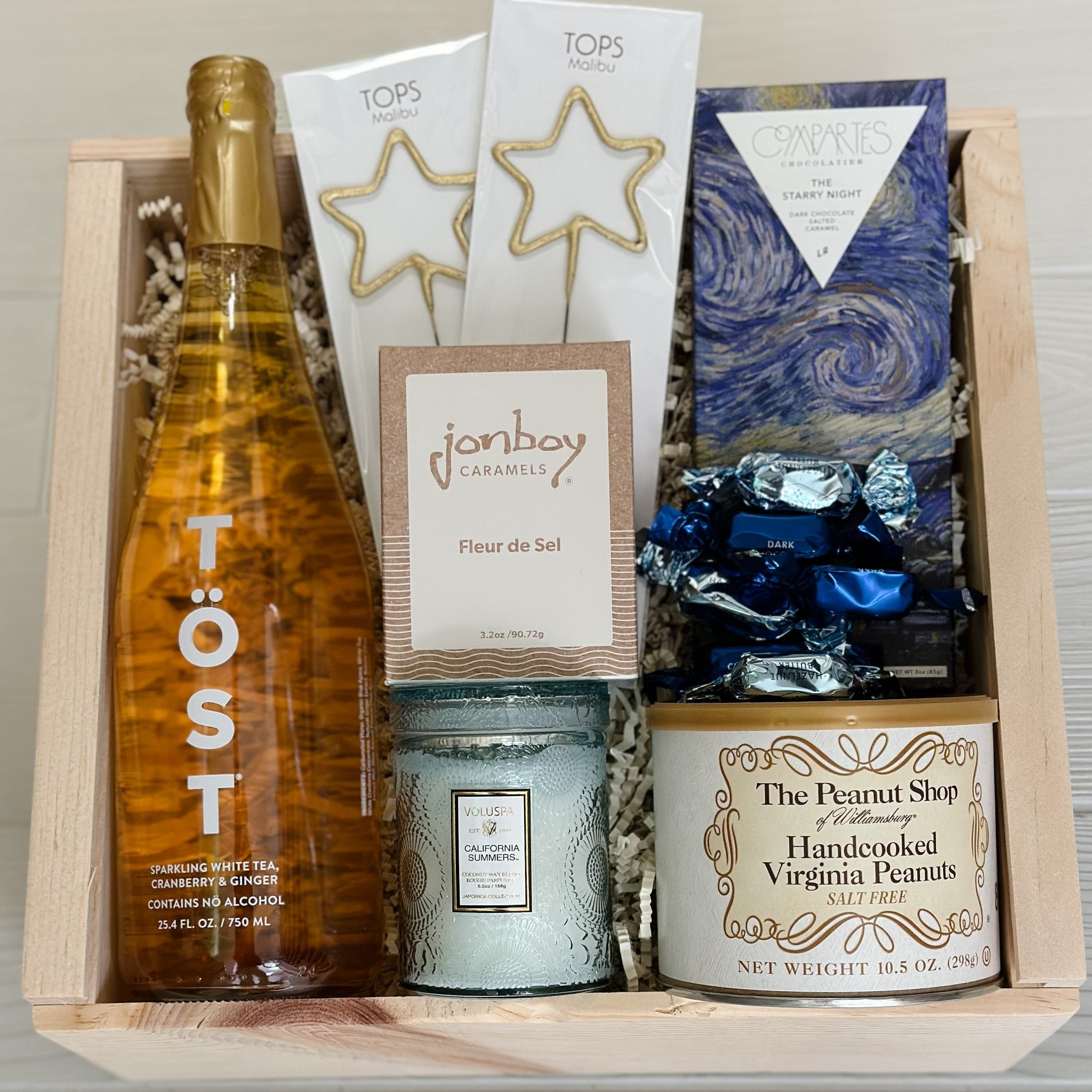 Celebrate non alcoholic gift basket includes sparkling beverage, sparklers, chocolate, caramel, peanuts, candle and truffles.