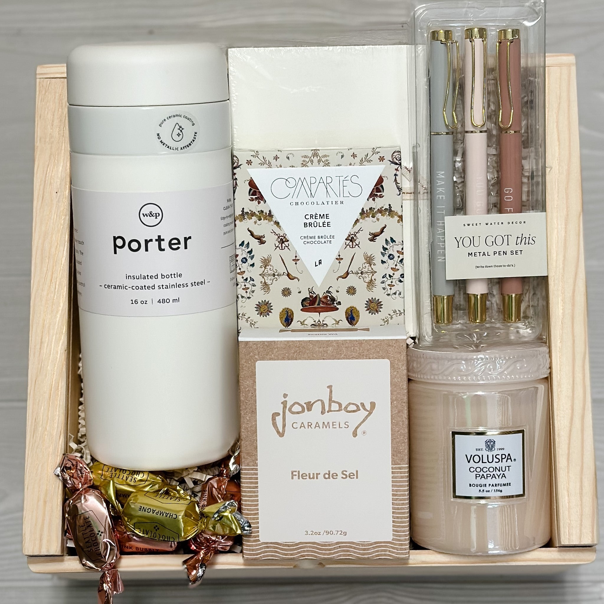 insulated bottle, notebooks, pens, chocolate, caramel, candle, truffles all packaged in our make it happen gift basket.