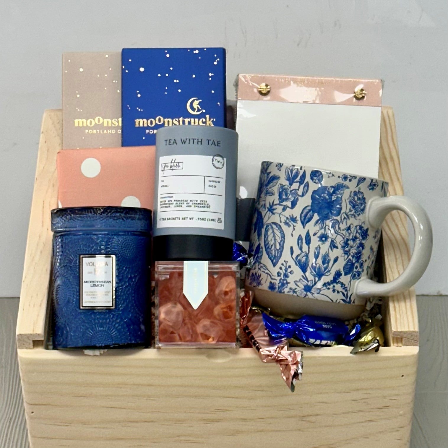 mug, tea, chocolate, notepad, shortbread, candle, candy all included in our whispers of blue gift basket.