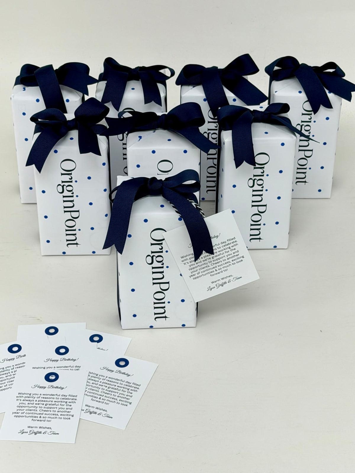 8 gifts wrapped in custom wrapping paper and tied with ribbon