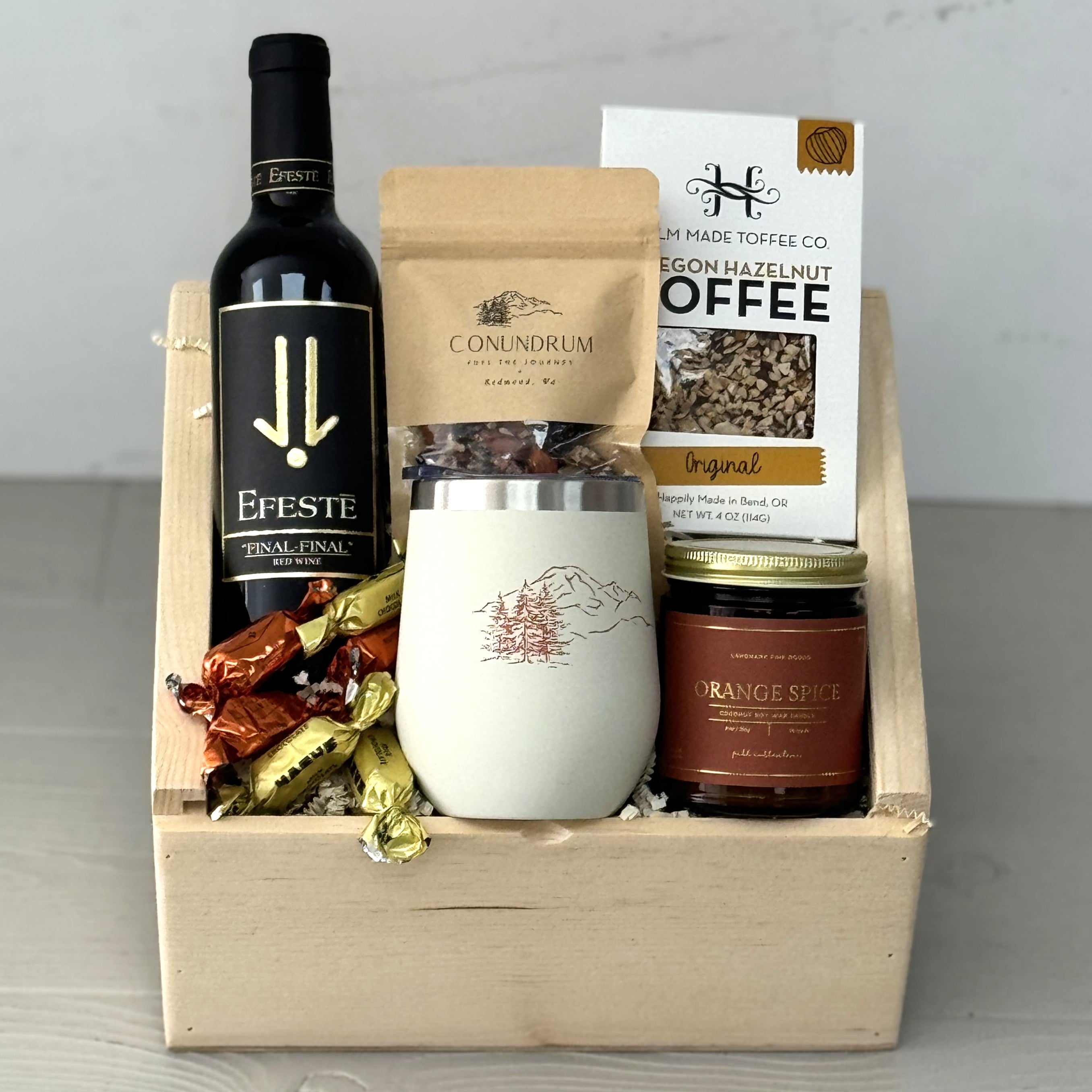 Gift basket with wine, toffee, trail mix, scented candle, chocolate, and tumbler