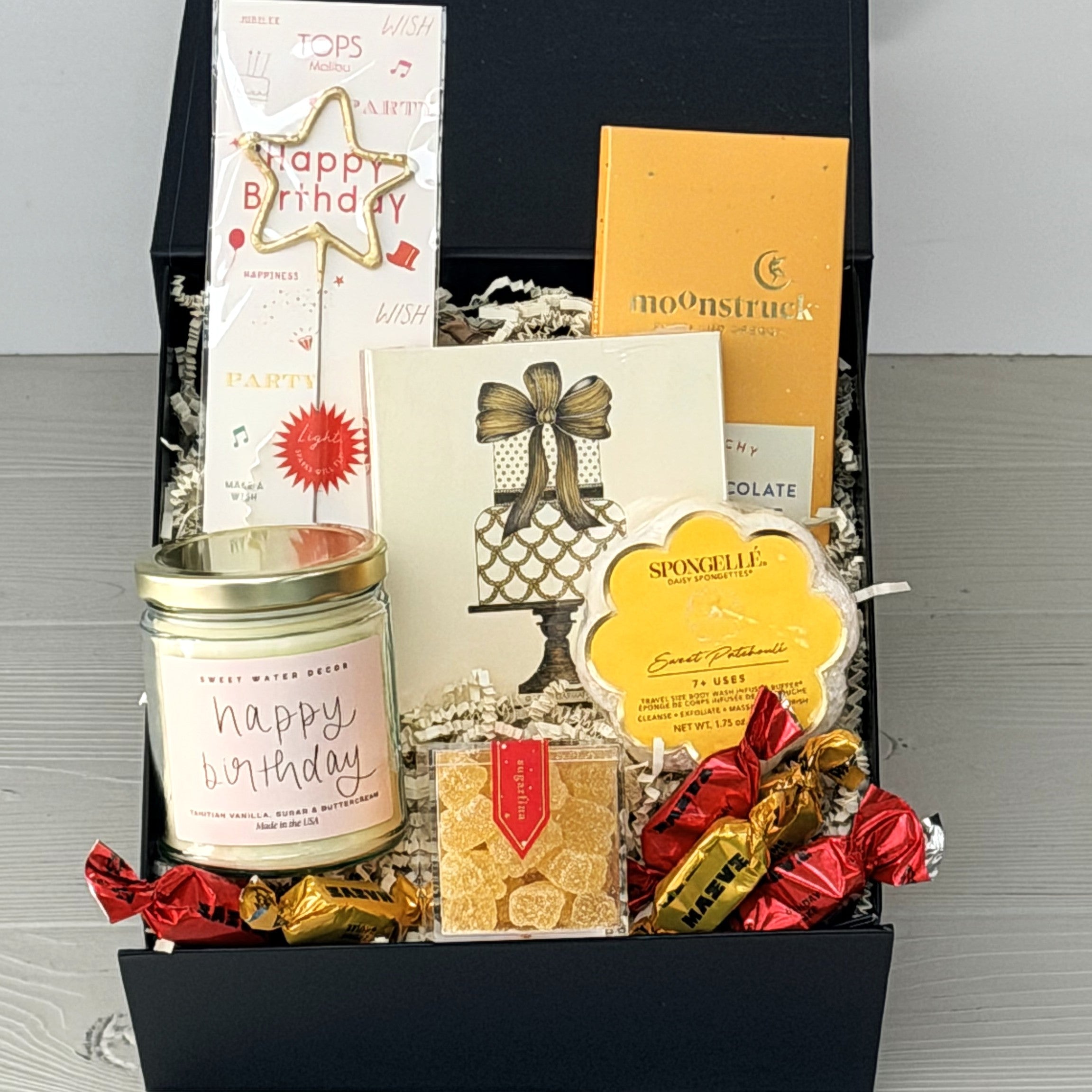 birthday gift basket includes a candle, matches, chocolate, sparkler