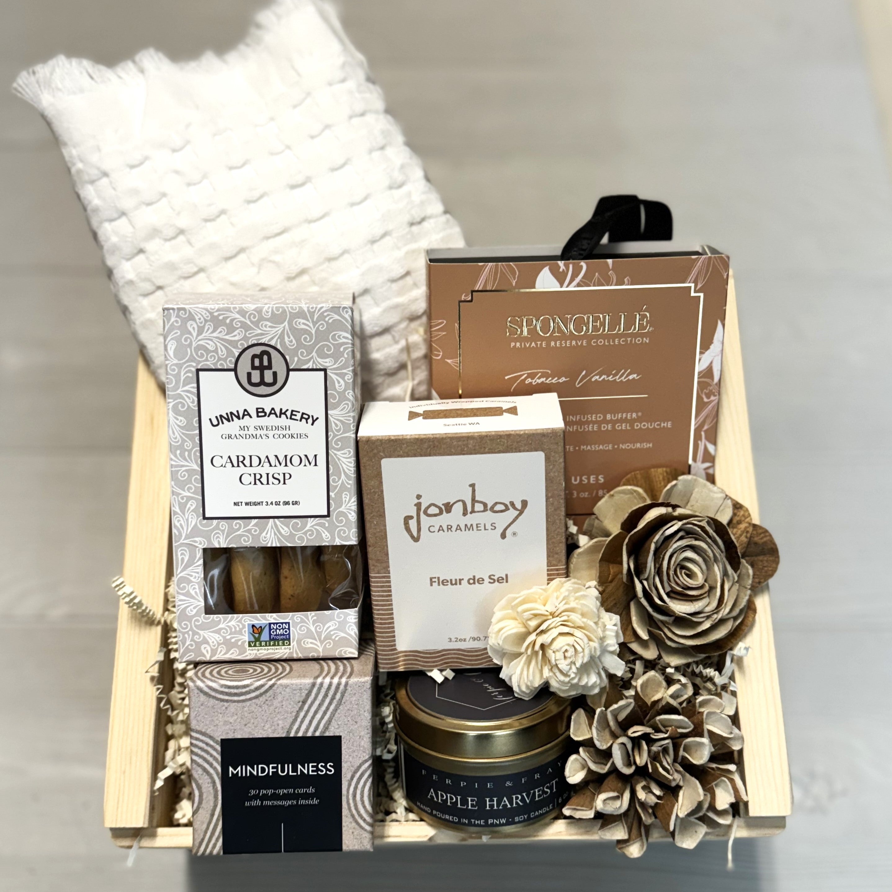 gift basket includes a hand towel, body buffing sponge, cookies, caramel, candle, boxed quotes