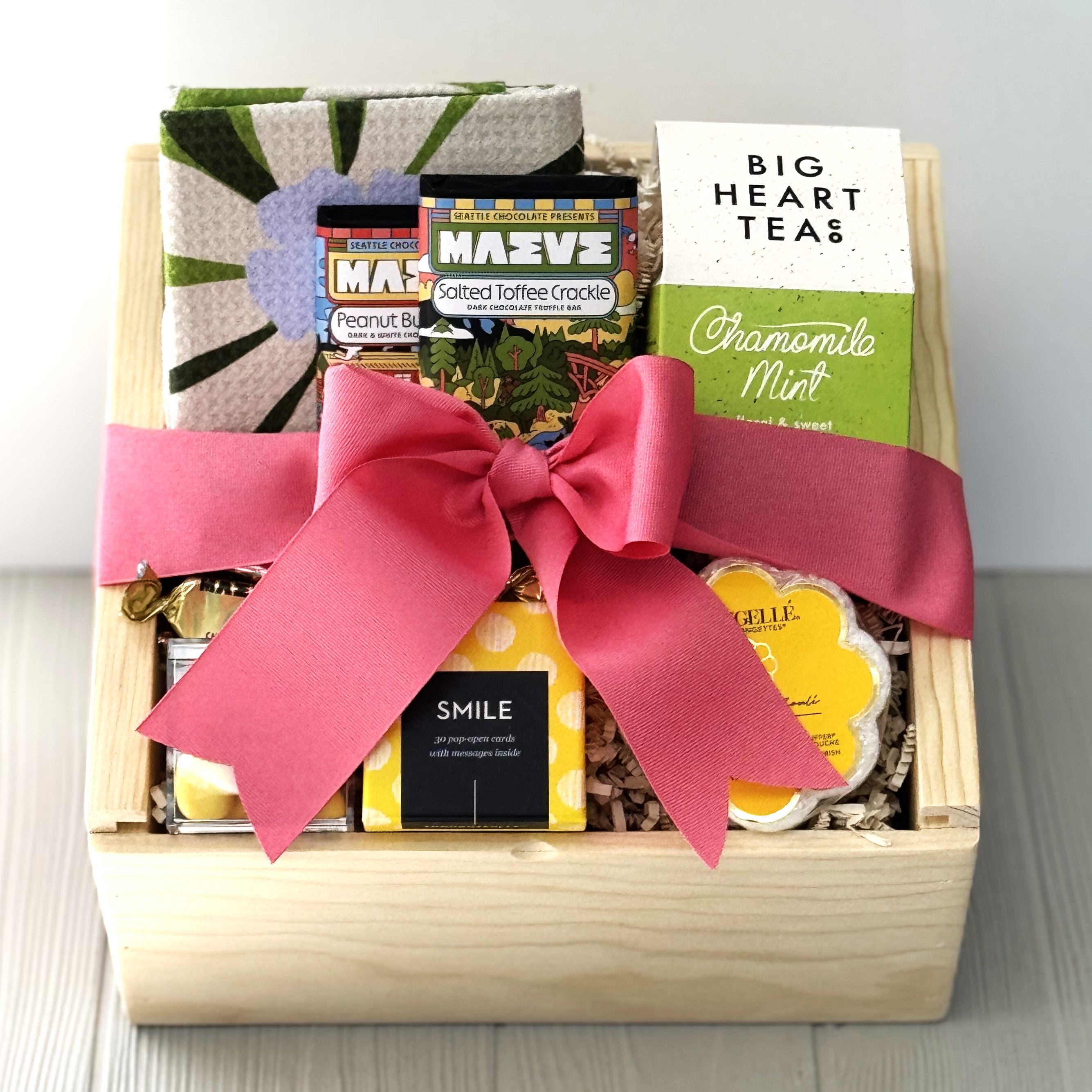 gift basket for Administrative Professionals Day that contains kitchen towel, chocolate, tea, candy, shower sponge