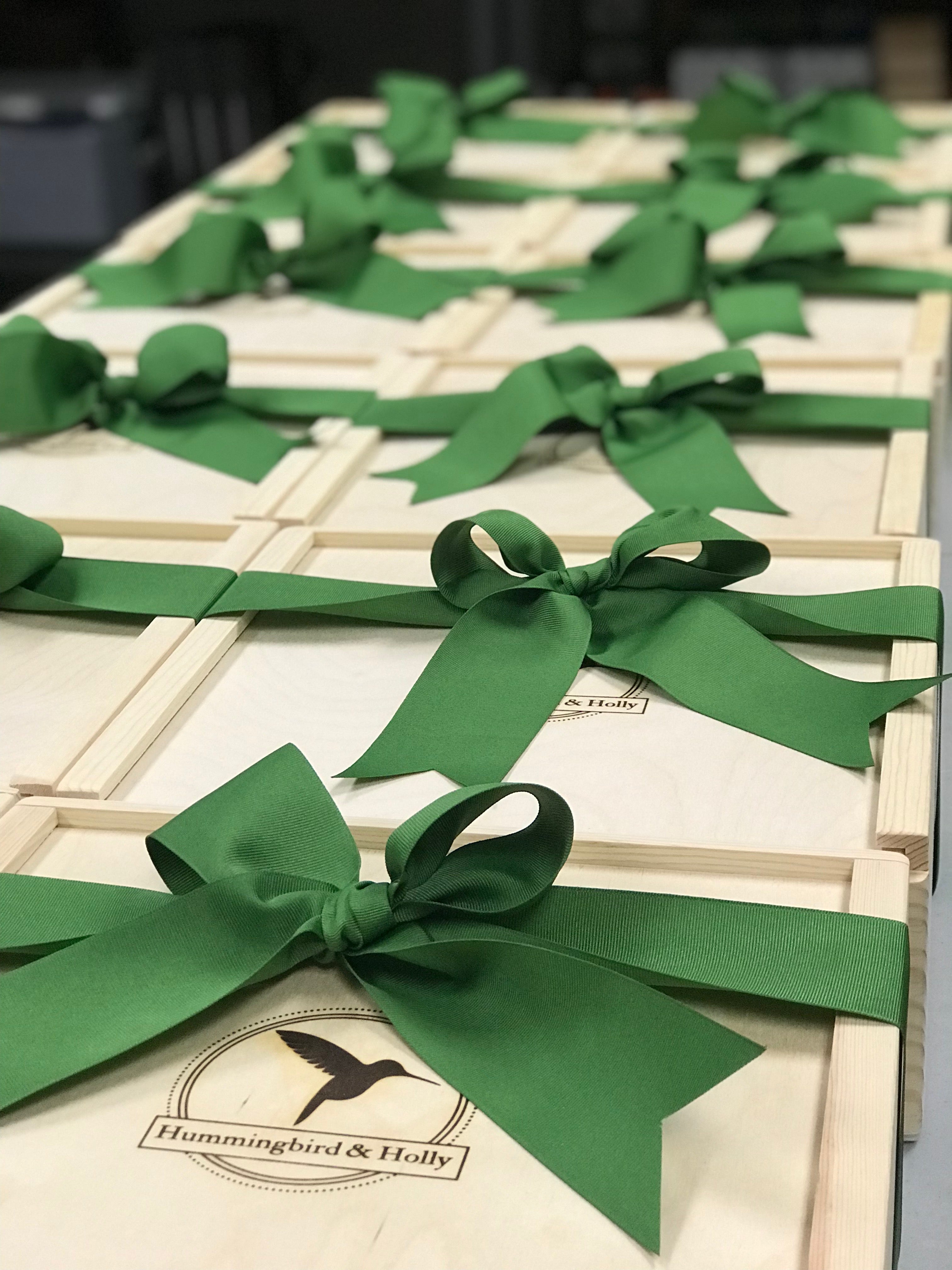 six wooden gift boxes with the Hummingbird and Holly logo, tied with green ribbon