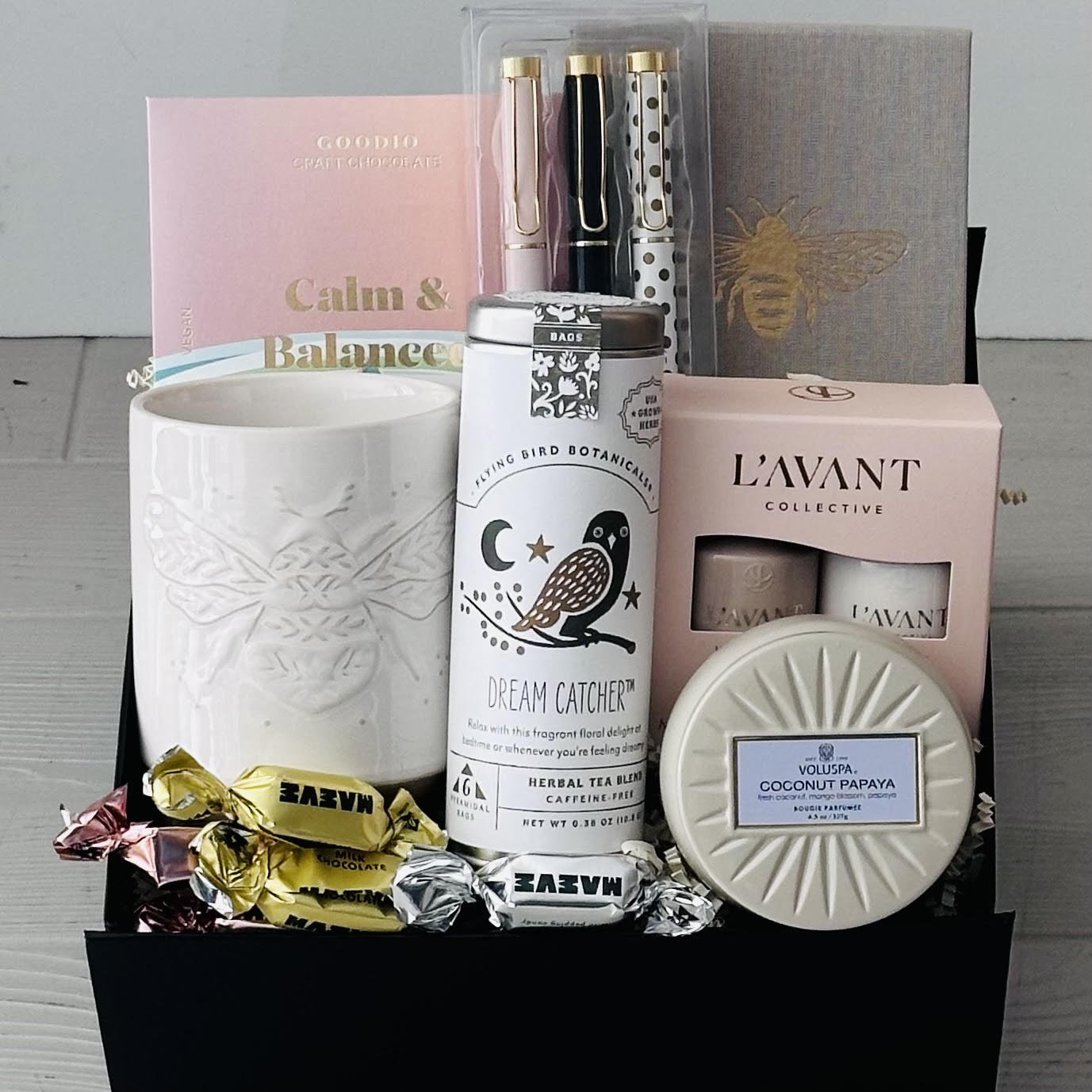 Mug, tea, chocolate, notebook, pens, hand cream, candle, chocolate included in our calm and balance gift box.