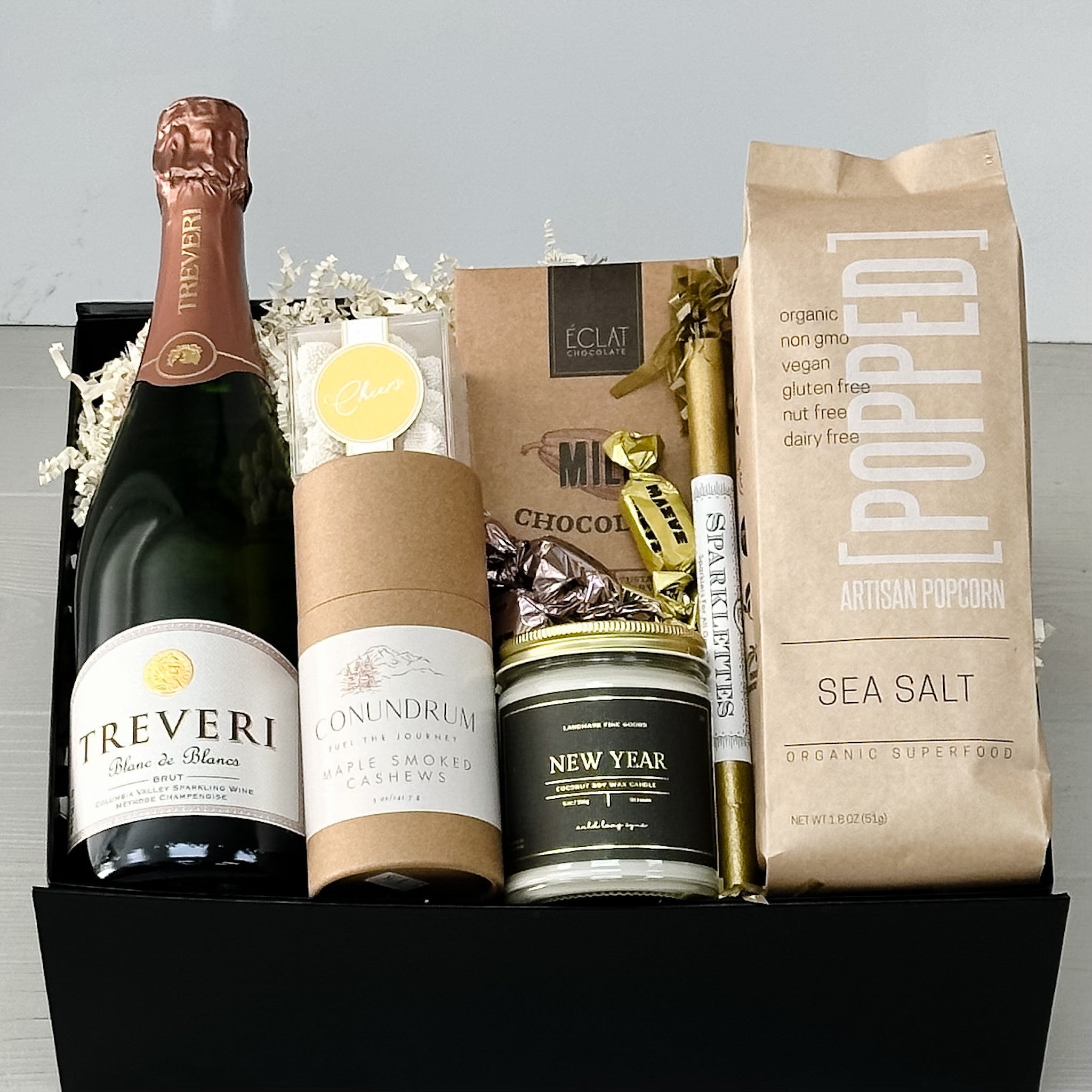 champagne, nuts, chocolate, candy, sparklers, popcorn, new year candle, all included in our celebrate the season gift basket.