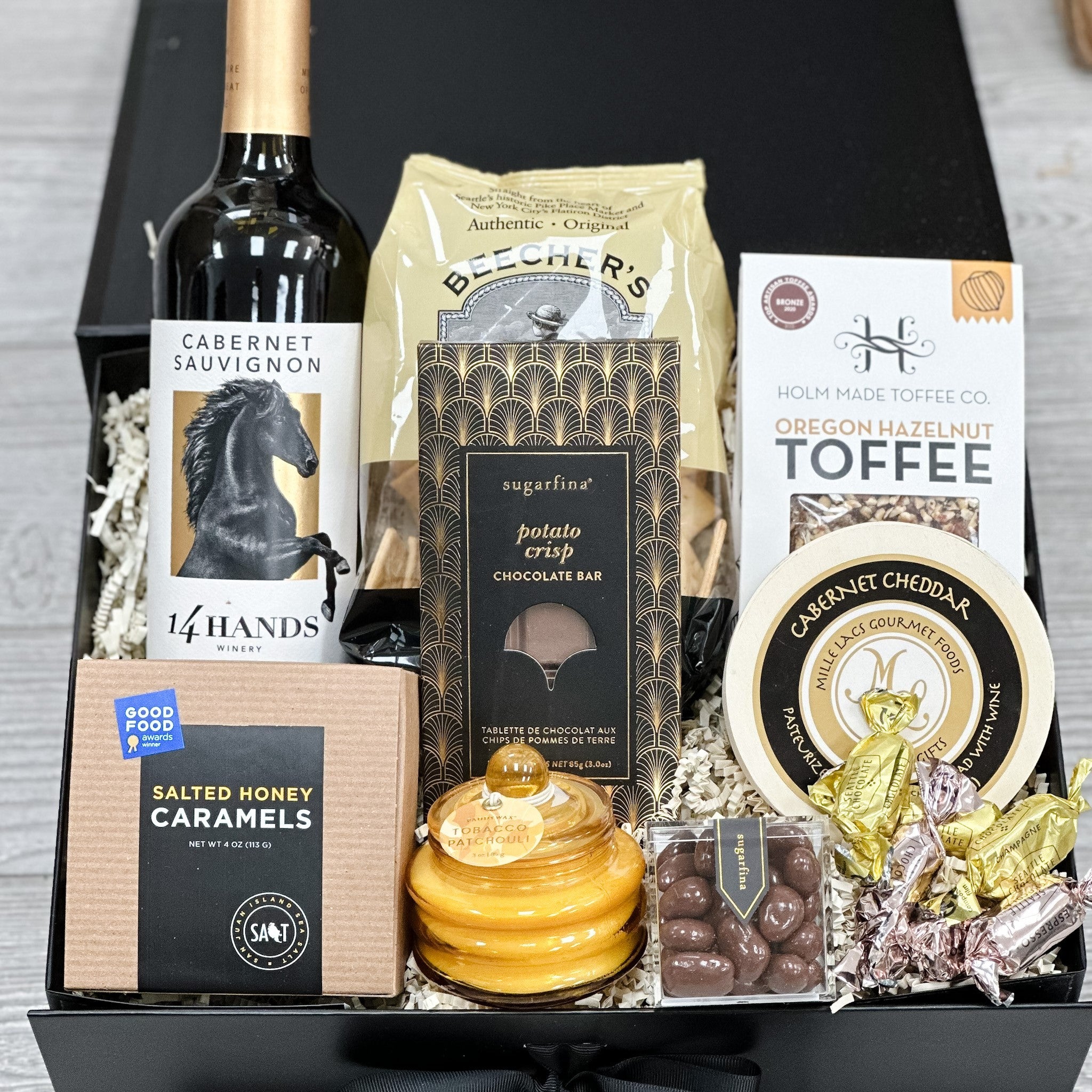 wine, crackers, cheese, toffee, chocolate, pecans, caramel and candle all packaged in our charcuterie with wine gift basket.
