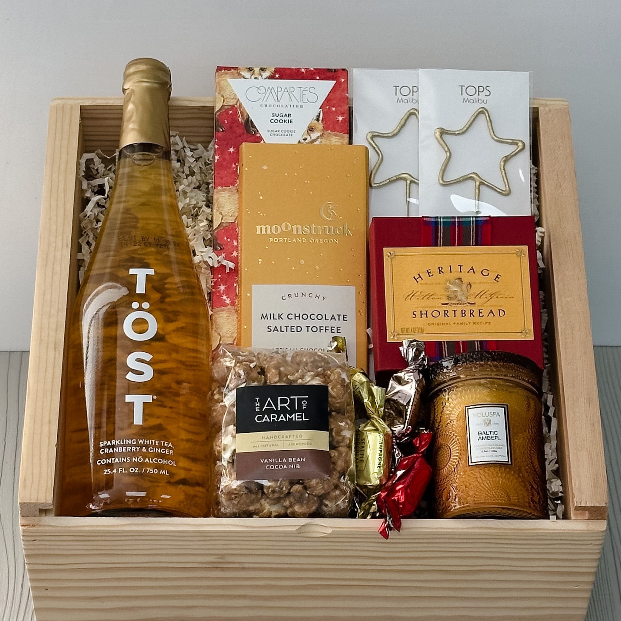 sparkling tea, chocolate, sparklers, shortbread, caramel corn, candle, and truffles all included in our cheers (non-alcoholic) gift basket