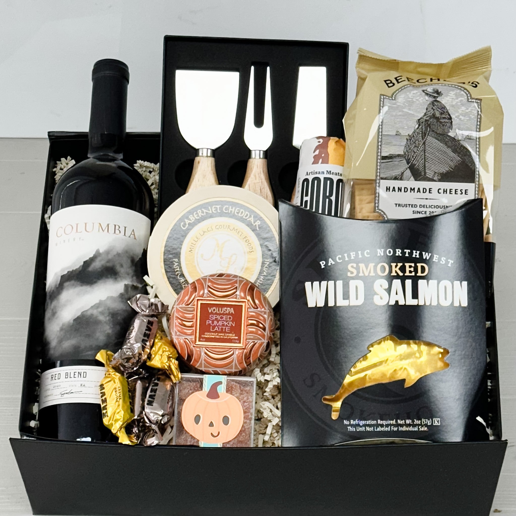 gift basket with wine, cheese knives, crackers, cheese, salami, smoked salmon, scented candle, chocolate