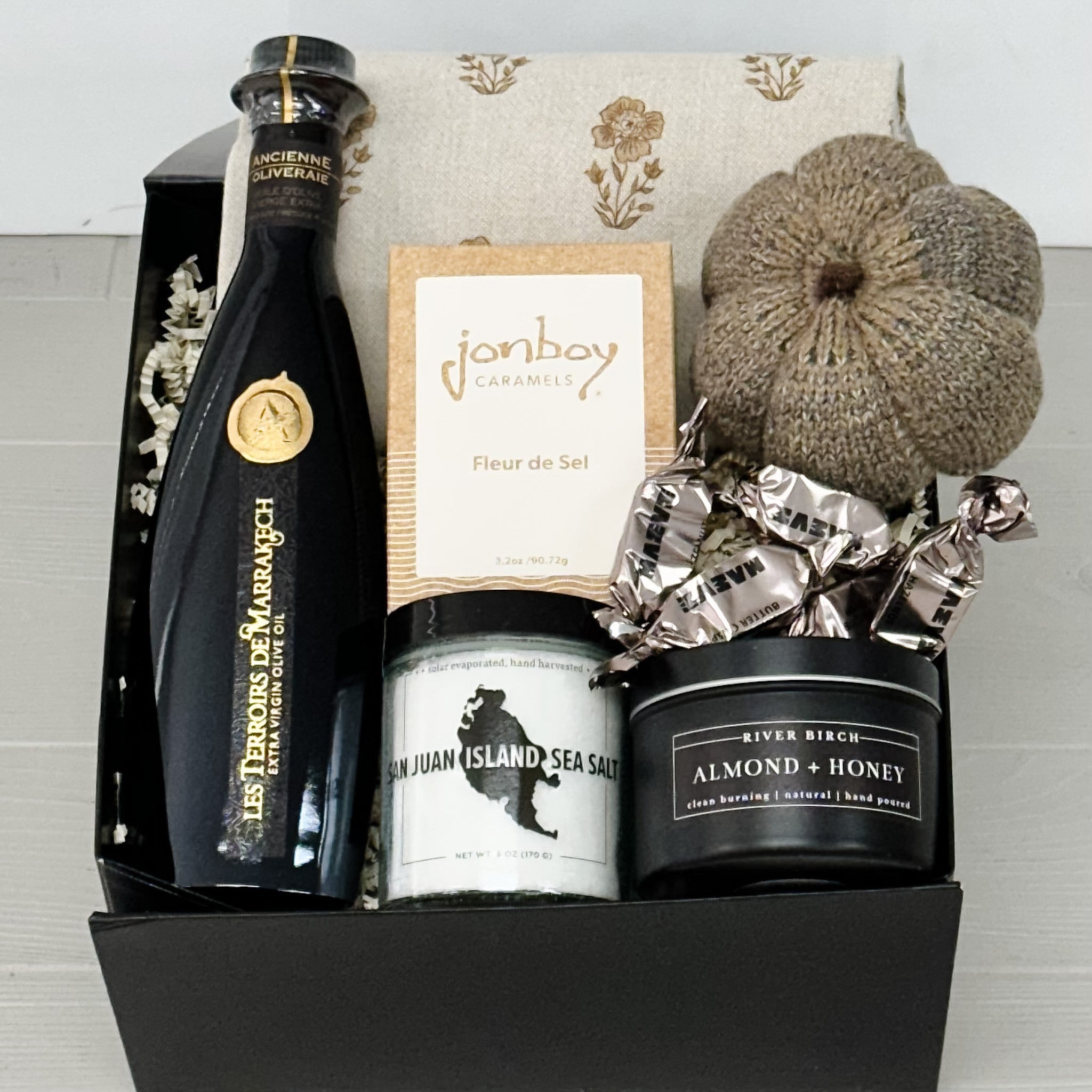 olive oil, sea salt, caramel, candle, tea towel and knit pumpkin included in gift our autumn harvest gift basket.