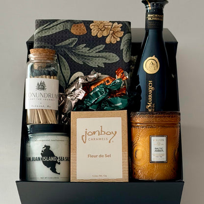 dish towel, olive oil, sea salt, caramel, candle, matches, truffles included in black gift box.