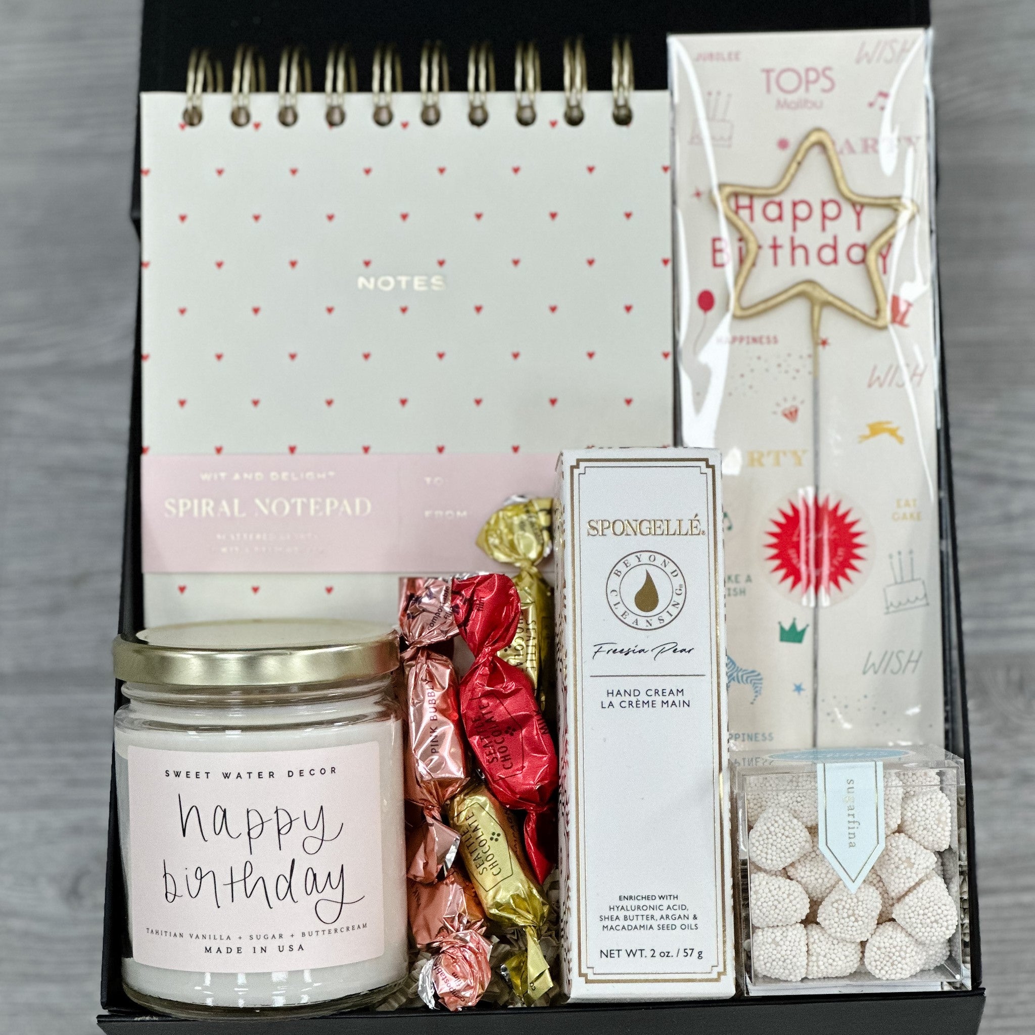 luxury notepad, candle, gold sparkler, hand cream, truffles, gummies all packaged in our birthday wishes gift basket
