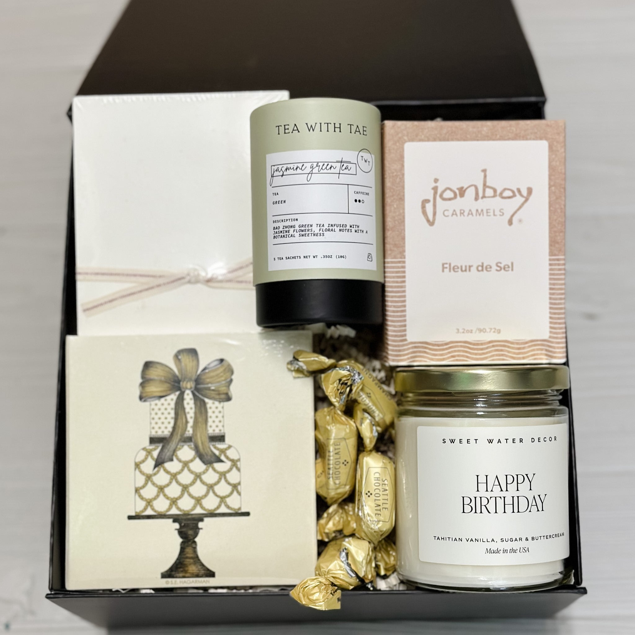 happy birthday candle, tea, caramel, matches, 2 jotter notebooks, truffles included in our Birthday Wishes gift basket