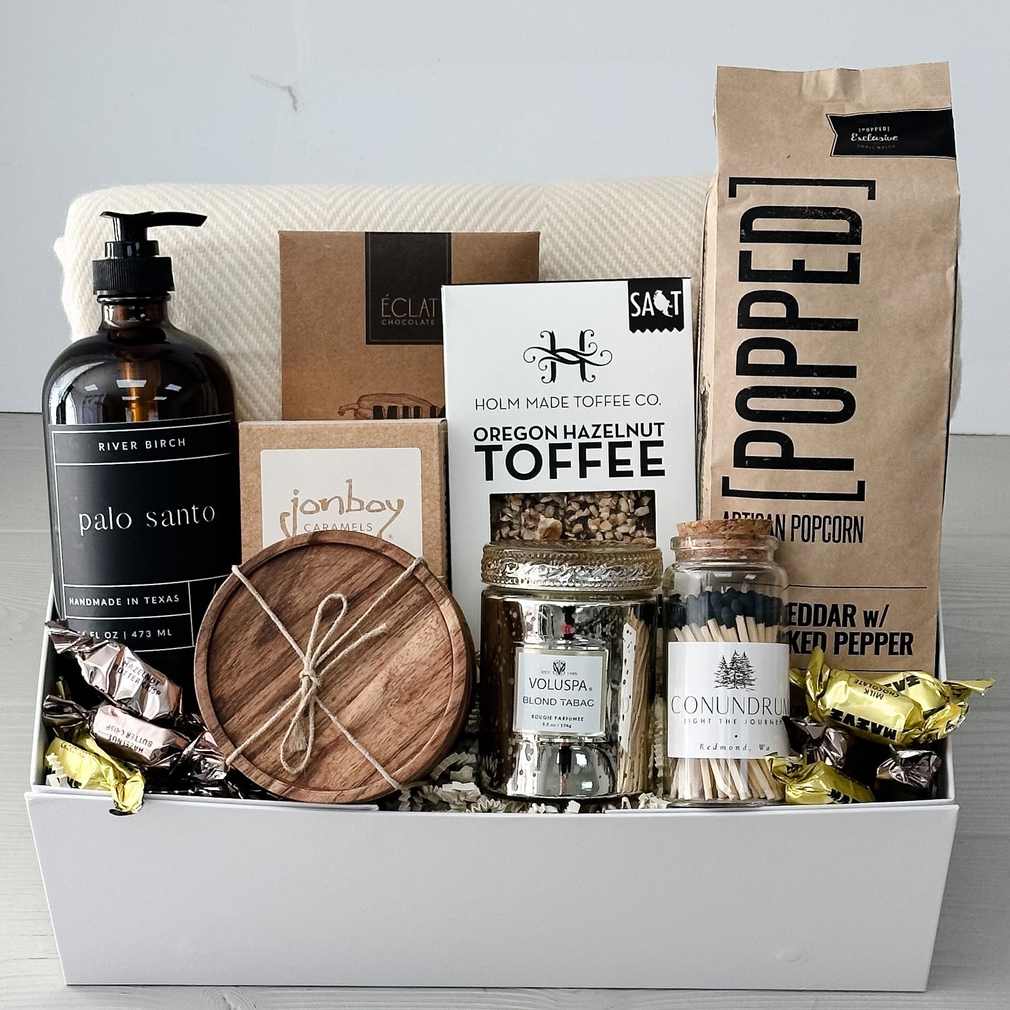 blanket, hand soap, coasters, candle, matches, snacks all included in our heart of home gift basket.