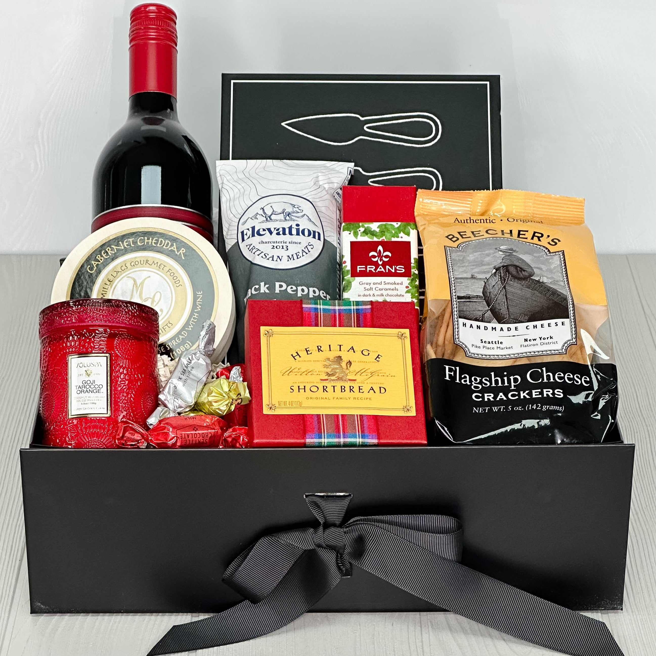 wine, cheese knives, cheese, salami, chocolate, shortbread, crackers, candle, truffles all included in our cheers & charcuterie gift basket
