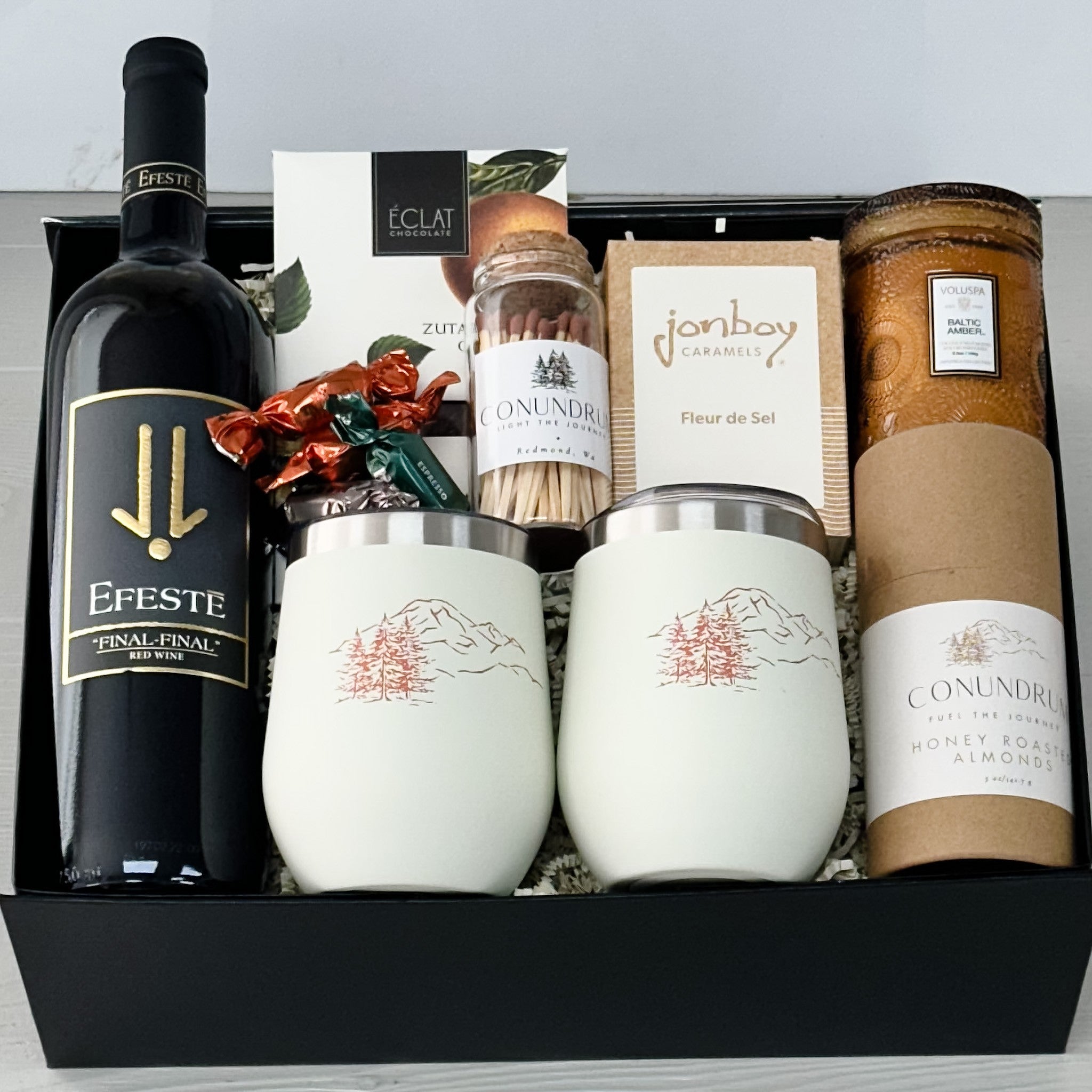 efeste wine, wine tumblers, maple smoked cashews, caramel, candle, matches, chocolate all included in our mountain cheer gift basket.
