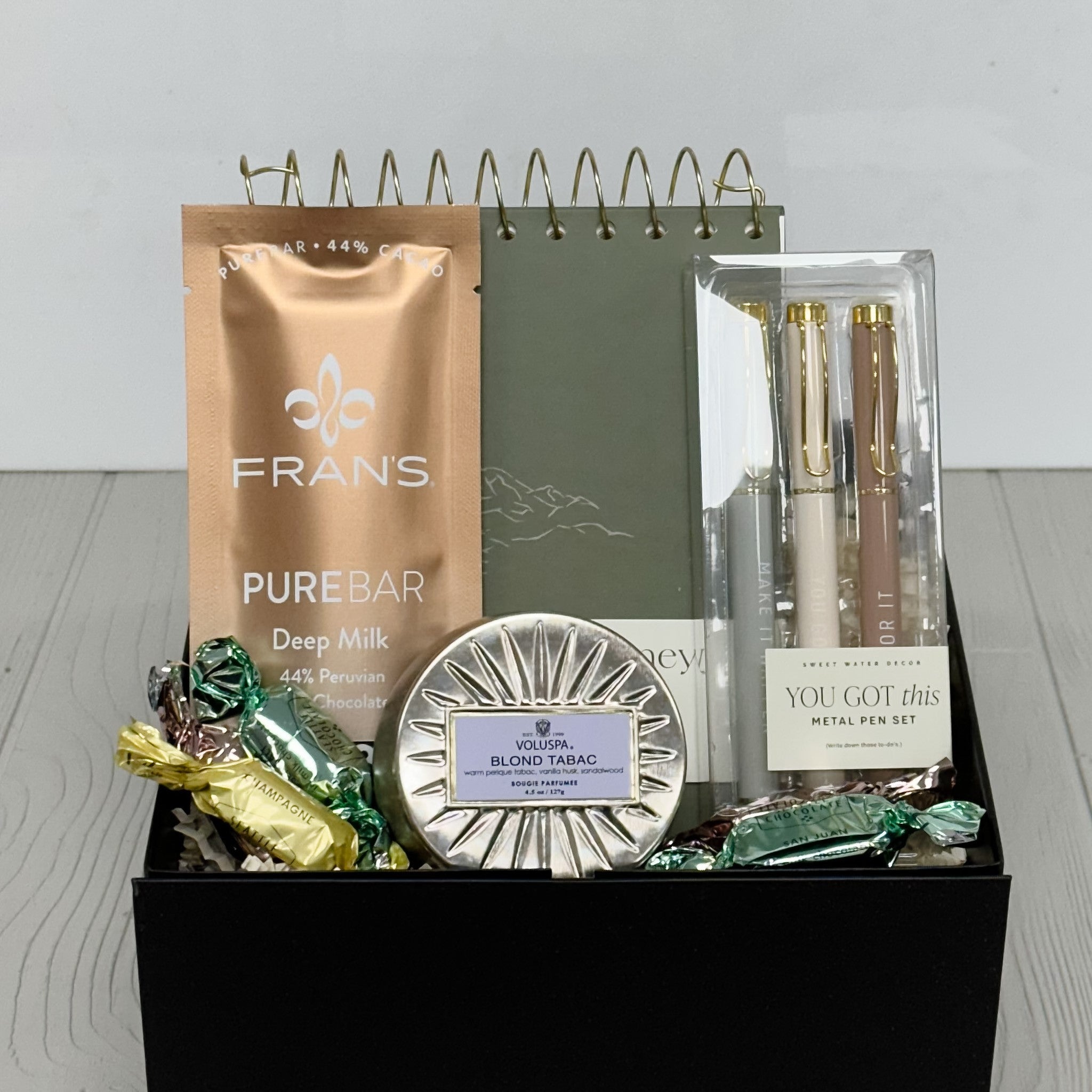 spiral notebook, pure bar by Frans, motivational pen set, candle truffles all included in our notes for your journey gift basket