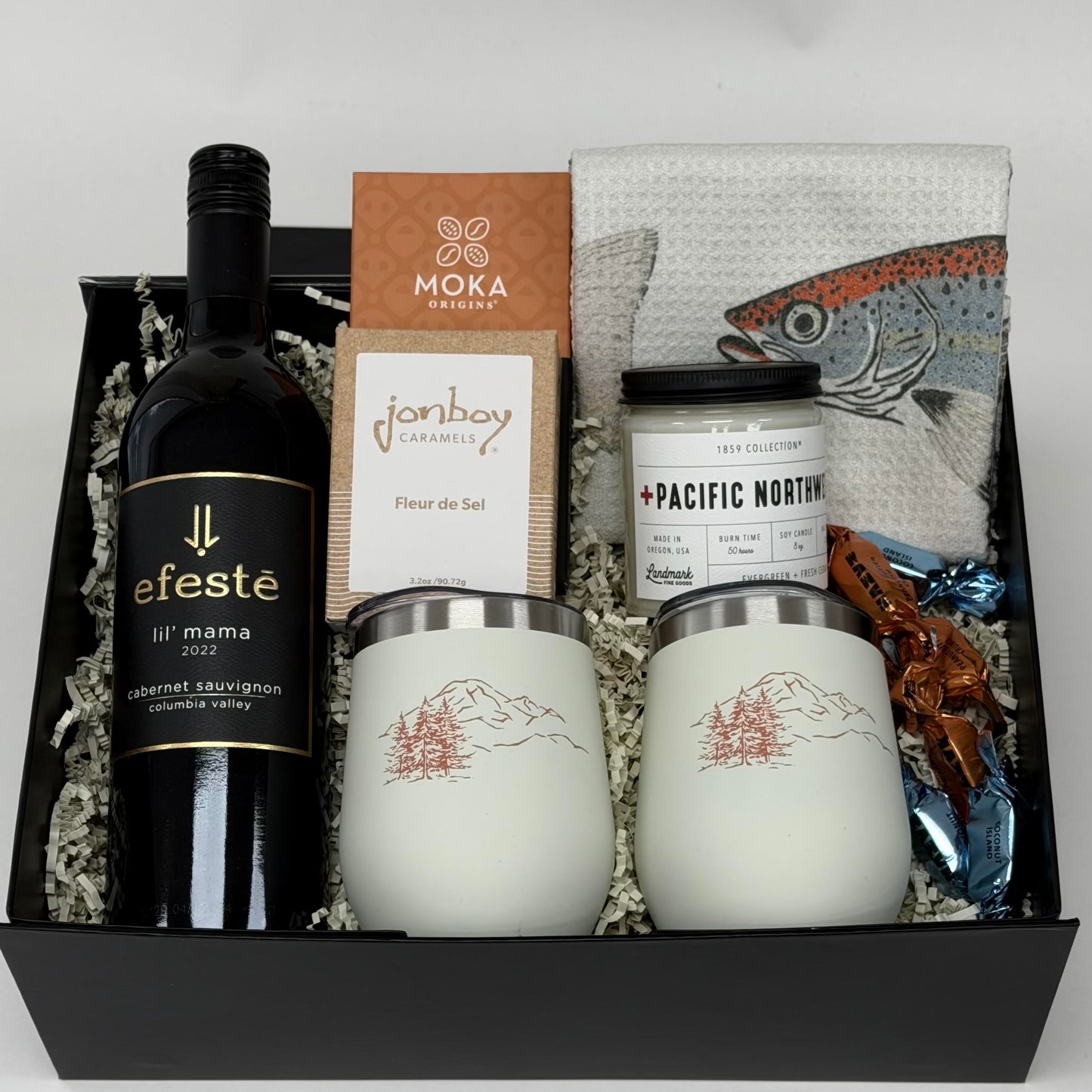 gift box with wine, wine tumblers, tea towel, chocolate, candle and caramel. 
