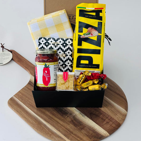wooden pizza peel, pizza dough, pizza sauce, dish towel, chocolate, pizza knives, candy, bonbons included in our pizza kit gift box.