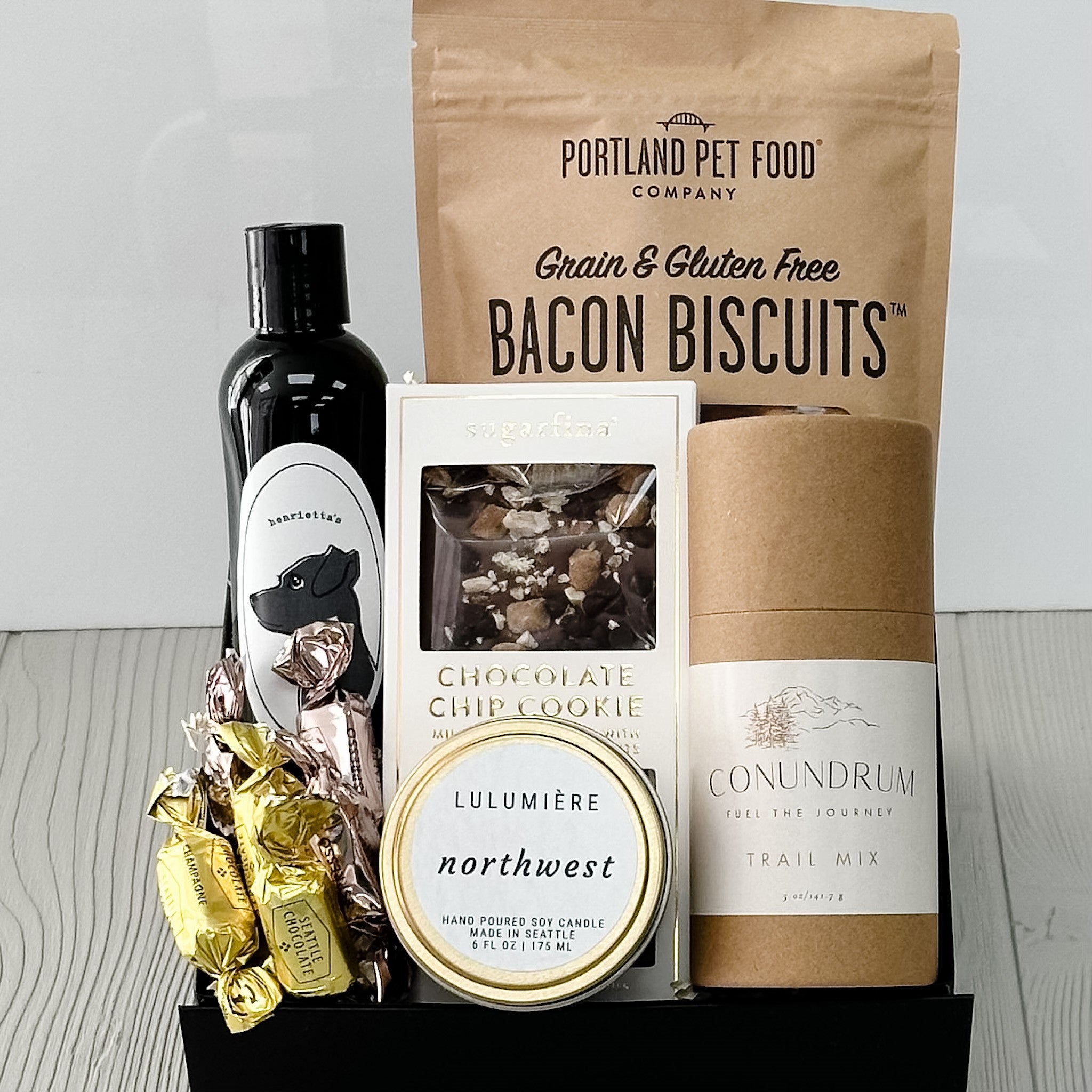 dog biscuits, dog wash, chocolate bar, trail mix, candle and truffles included in our puppy love gift basket.