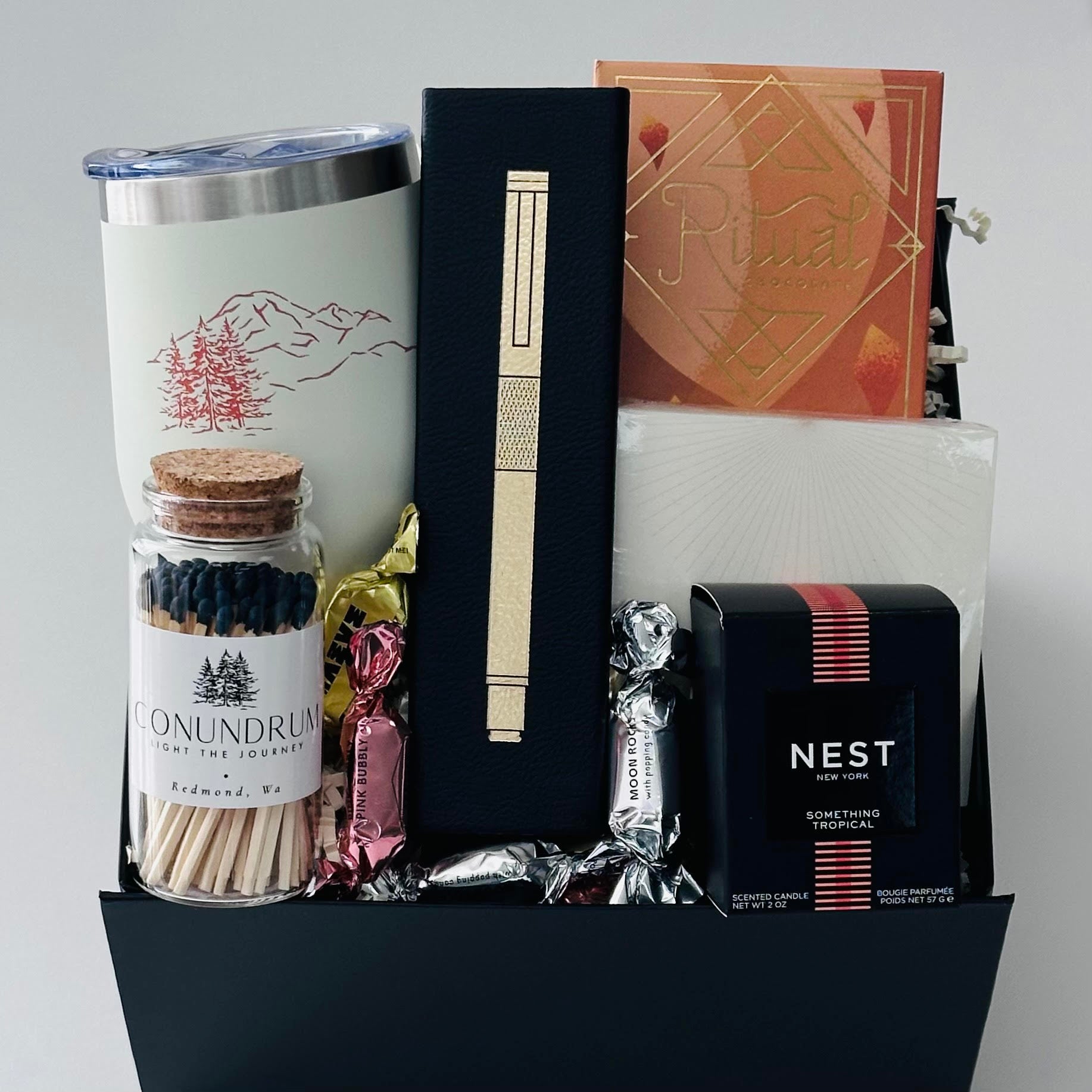 wine tumbler, gold pen, note pad, chocolate, candle, matches, packaged in our black box.