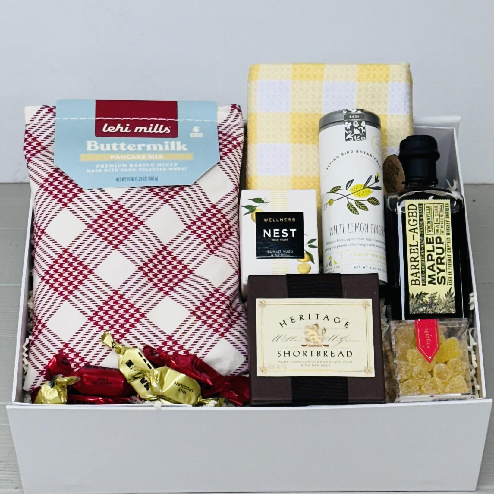 Pancake mix, syrup, tea towel, tea, scented candle, shortbread, candy, chocolate all packaged in our Pancakes and Sunshine gift box.