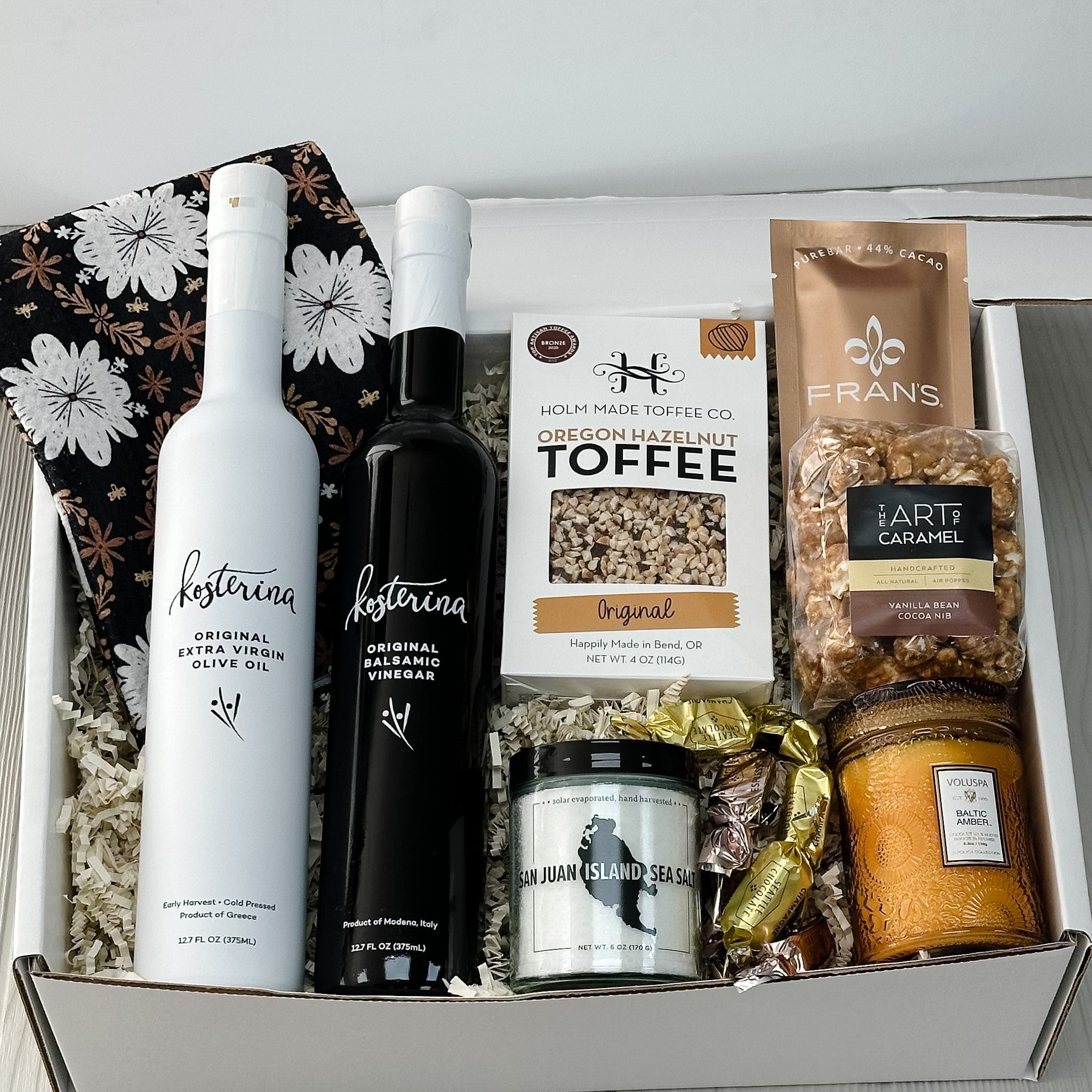 olive oil, balsamic vinegar, sea salt, toffee, candle, chocolate, caramel corn included in our welcome home gift basket