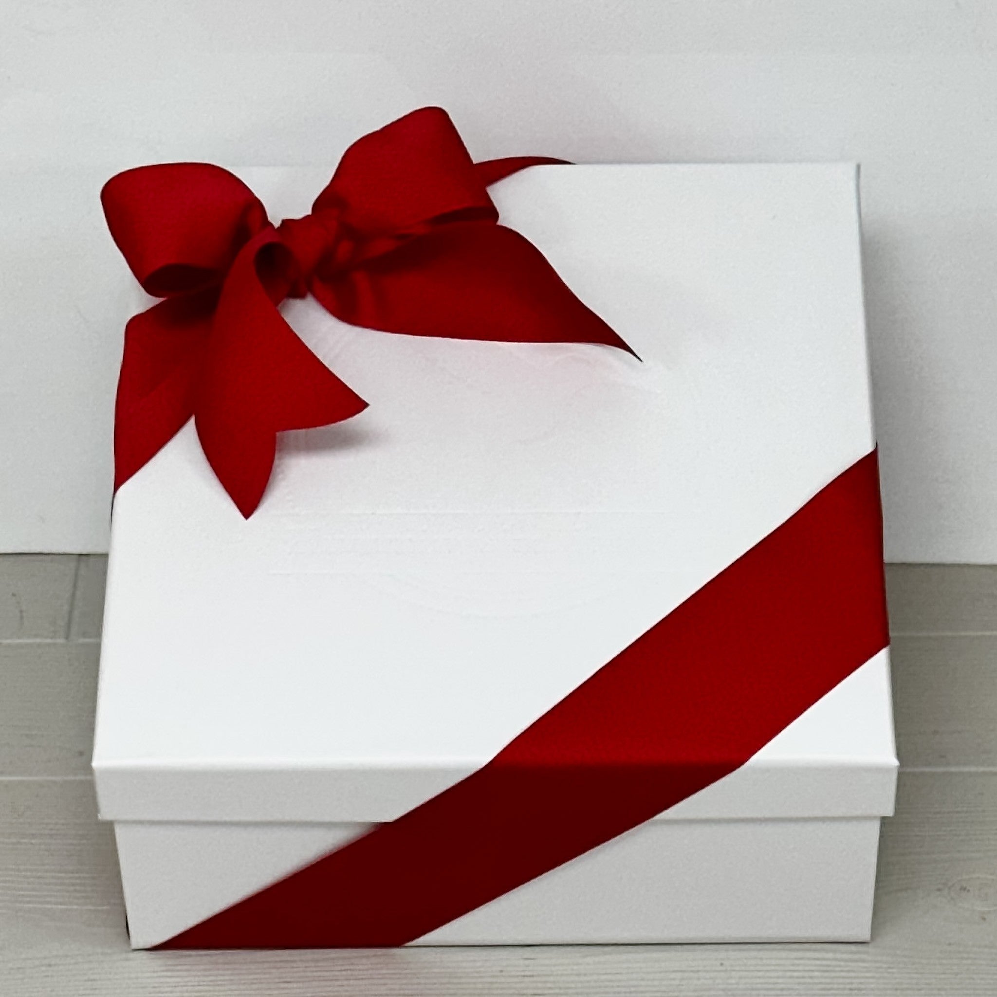 close up of white box with red ribbon