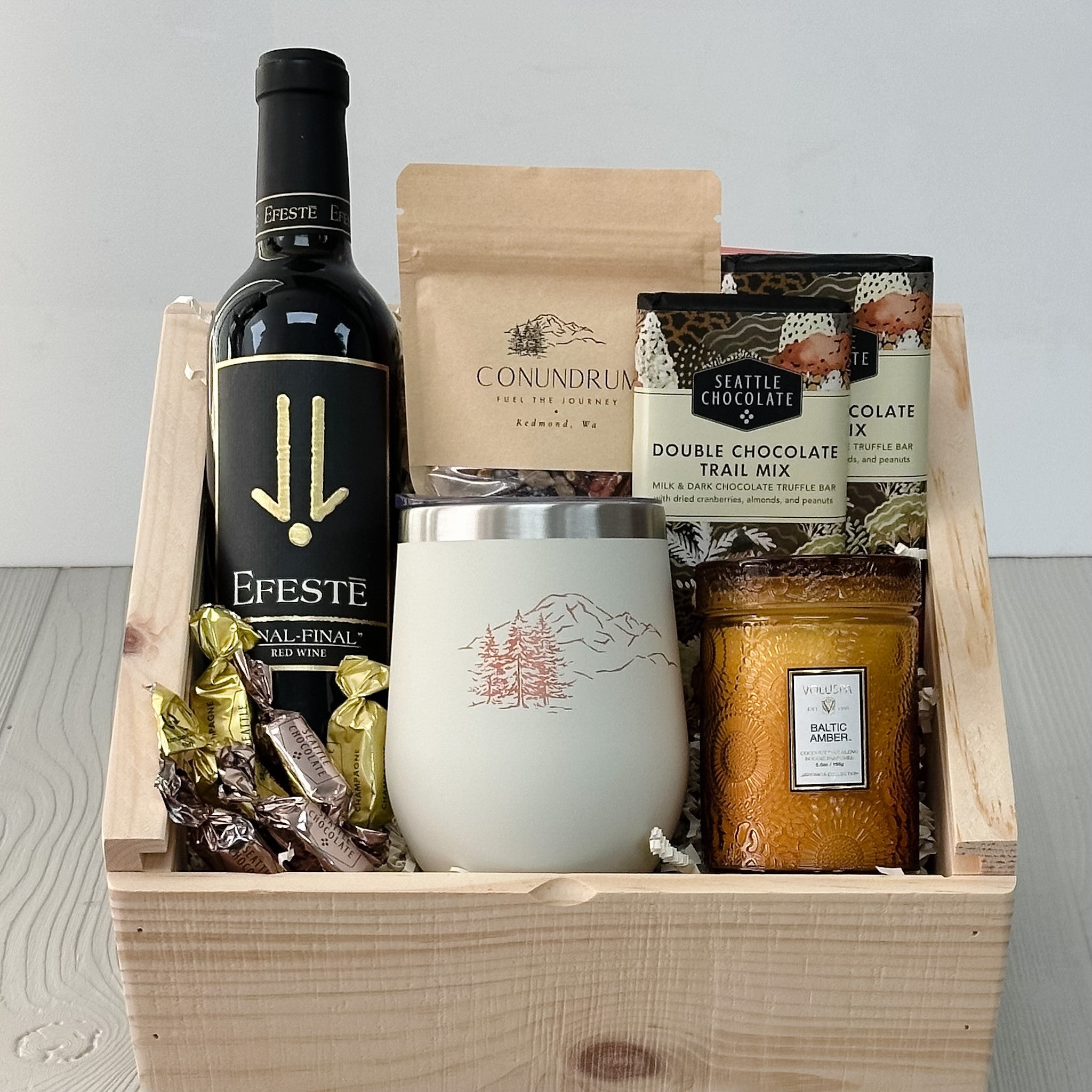 375 ml bottle of wine, wine tumbler, trail mix, chocolate candle all included in our PNW sip and savor gift basket