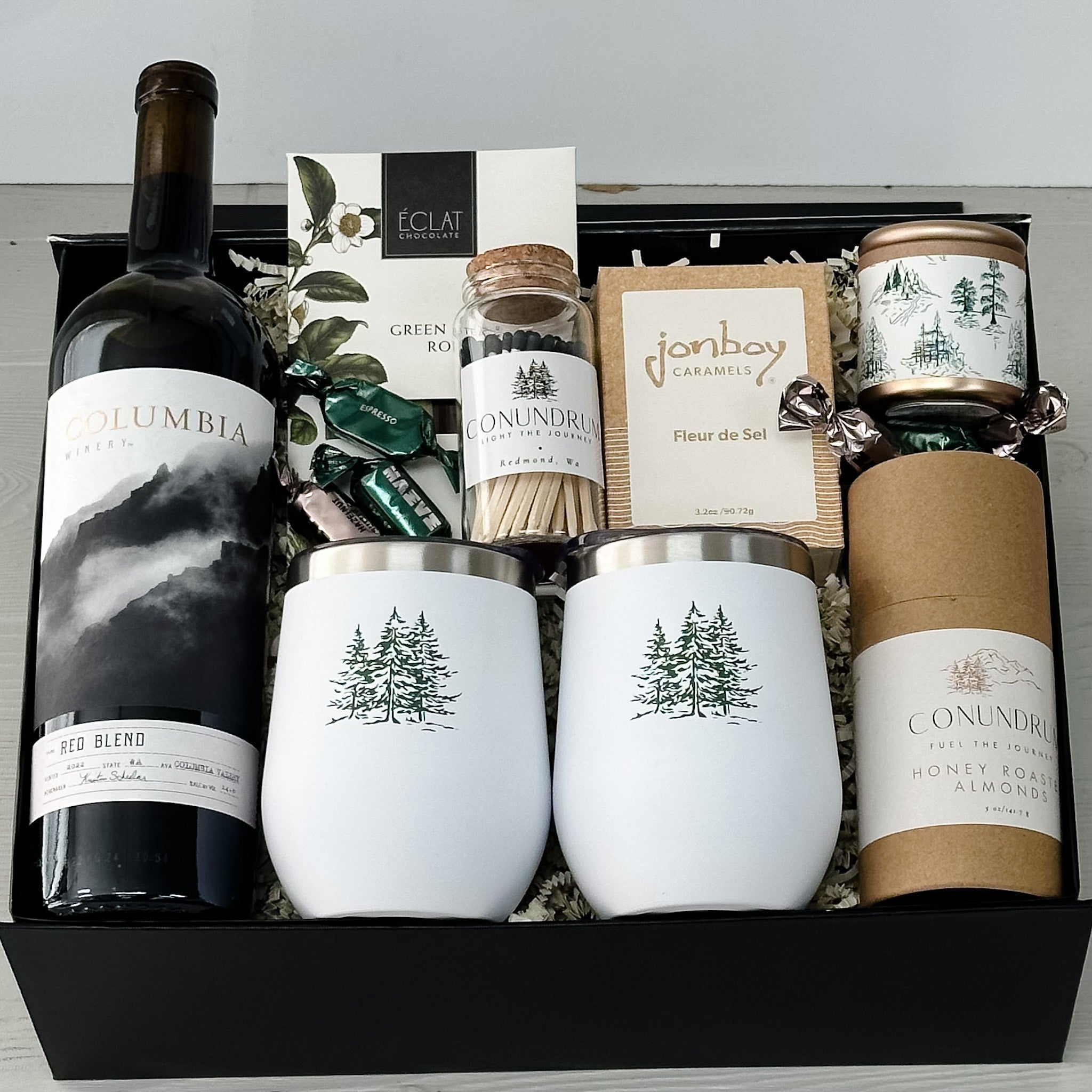 columbia valley red wine, wine tumblers, chocolate, candle, matches, caramel and cashews all included in our winter celebrations gift basket