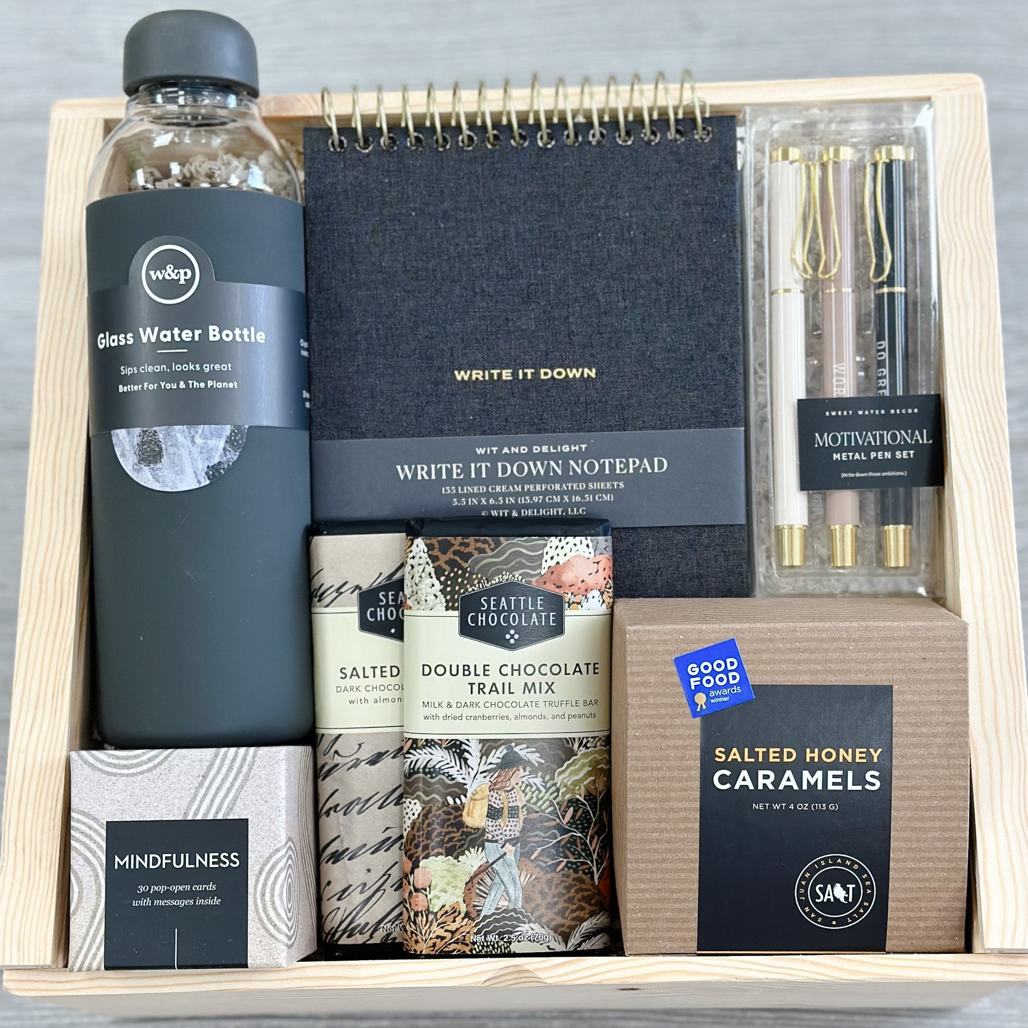 glass water bottle, luxury notepad, motivational pens, caramels, chocolate bars, inspirational quotes all packaged in our "you got this" gift basket